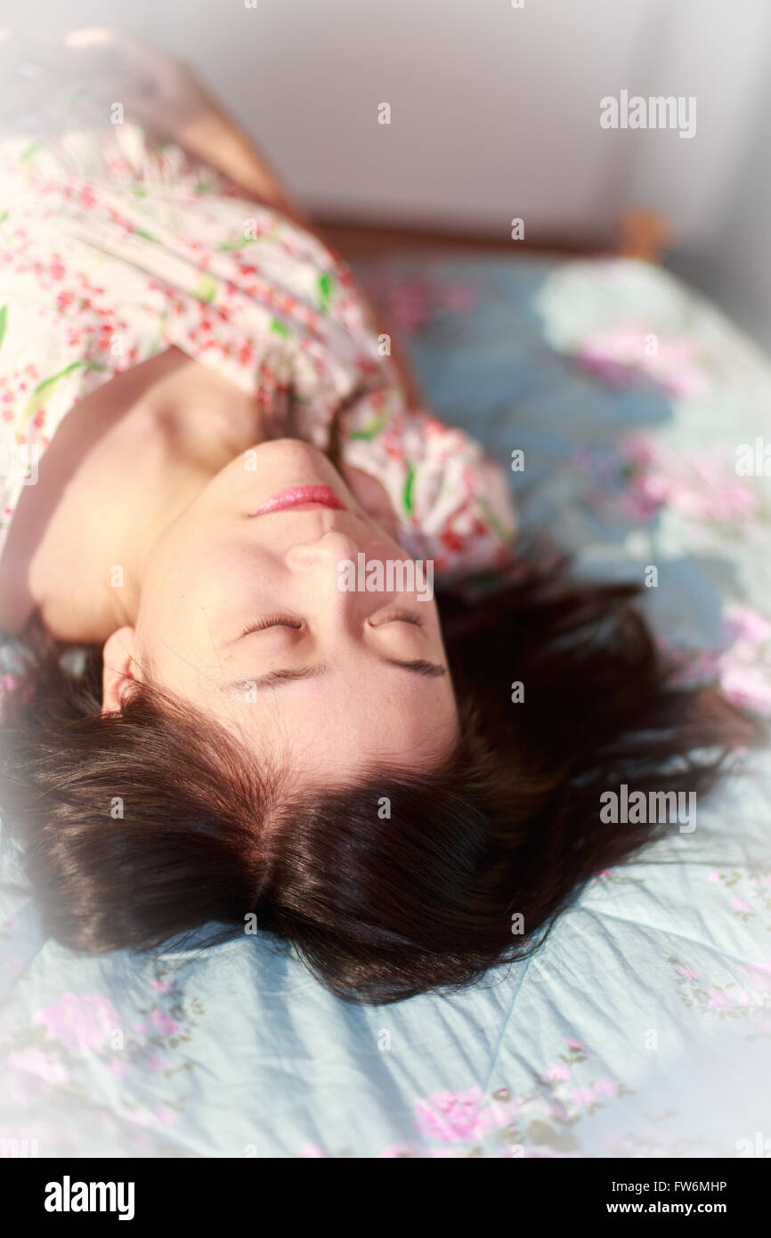 Una bellissima femmina occhi chiusi giacciono nel letto Foto Stock