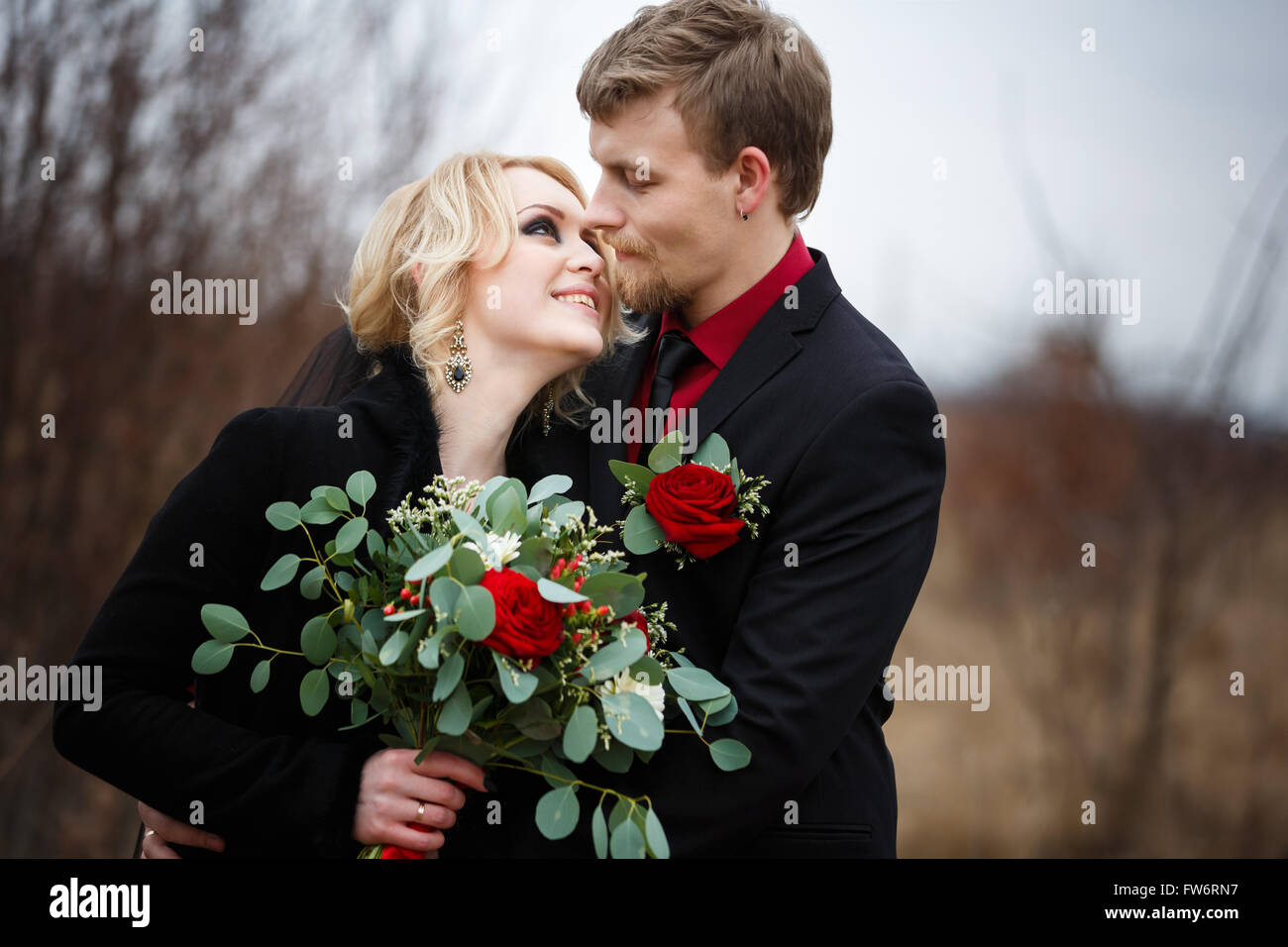 Felice costeggiata coppie in viaggio di nozze con bouquet in legno Foto Stock