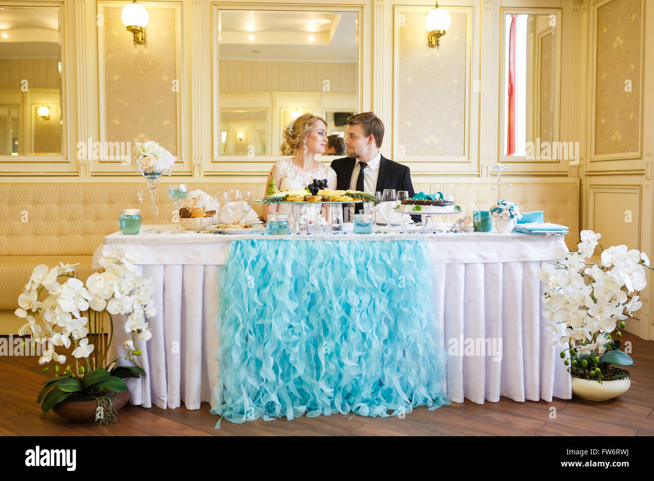 Sposi seduti a tavola su un banchetto Foto Stock
