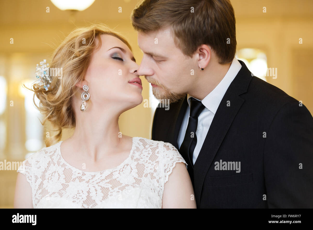 Abbracciando coppie in viaggio di nozze in una sala luminosa Foto Stock