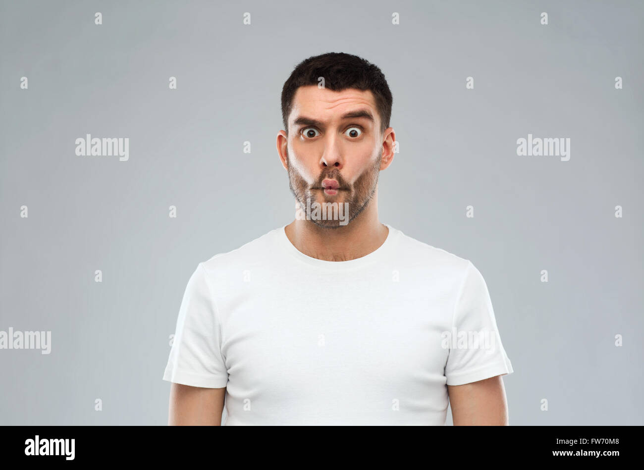 L'uomo con il pesce faccia su sfondo grigio Foto Stock