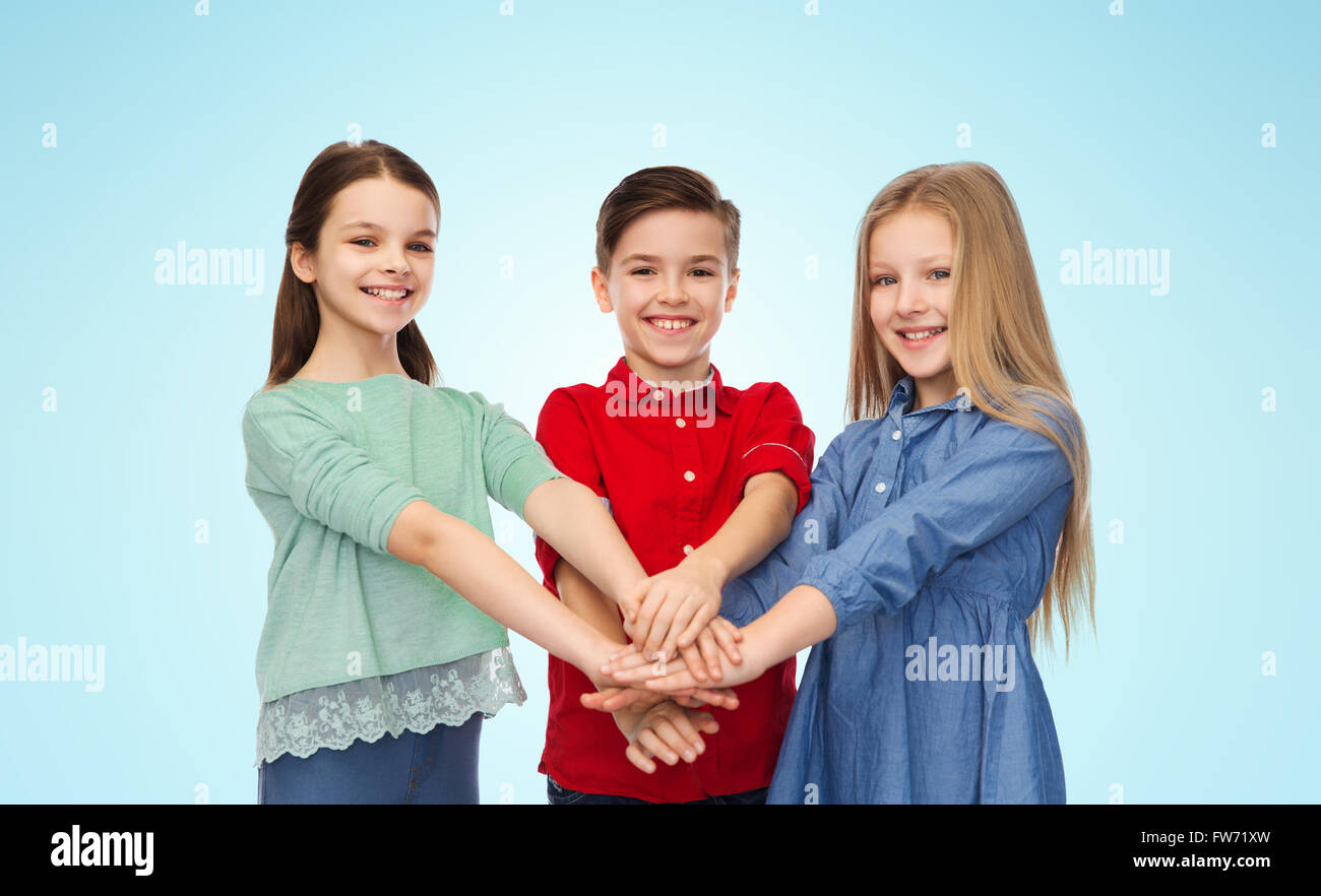 Felice ragazzo e ragazze con le mani sulla parte superiore Foto Stock