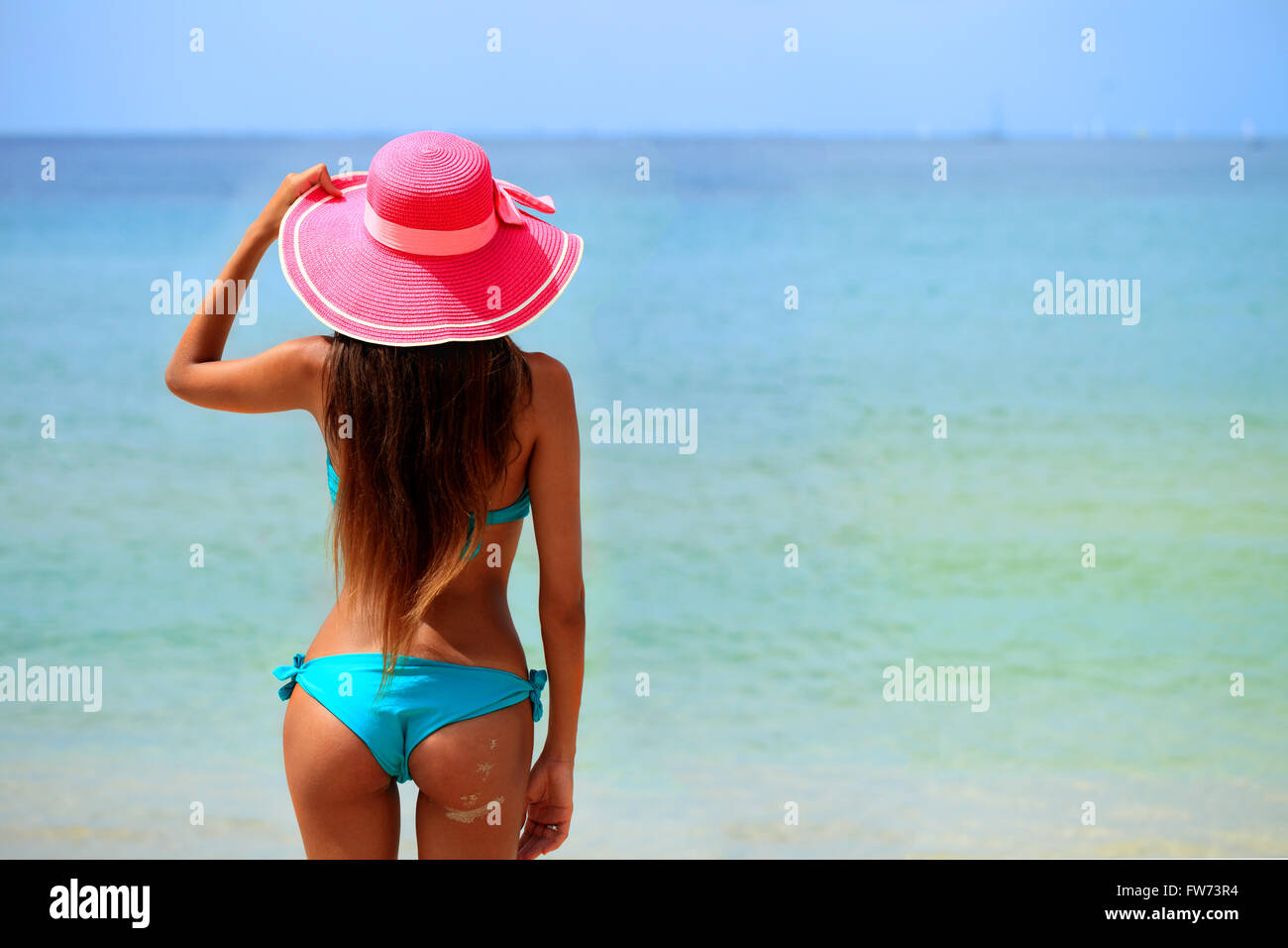Donna in grande cappello seduto sulla spiaggia in riva al mare Foto stock -  Alamy