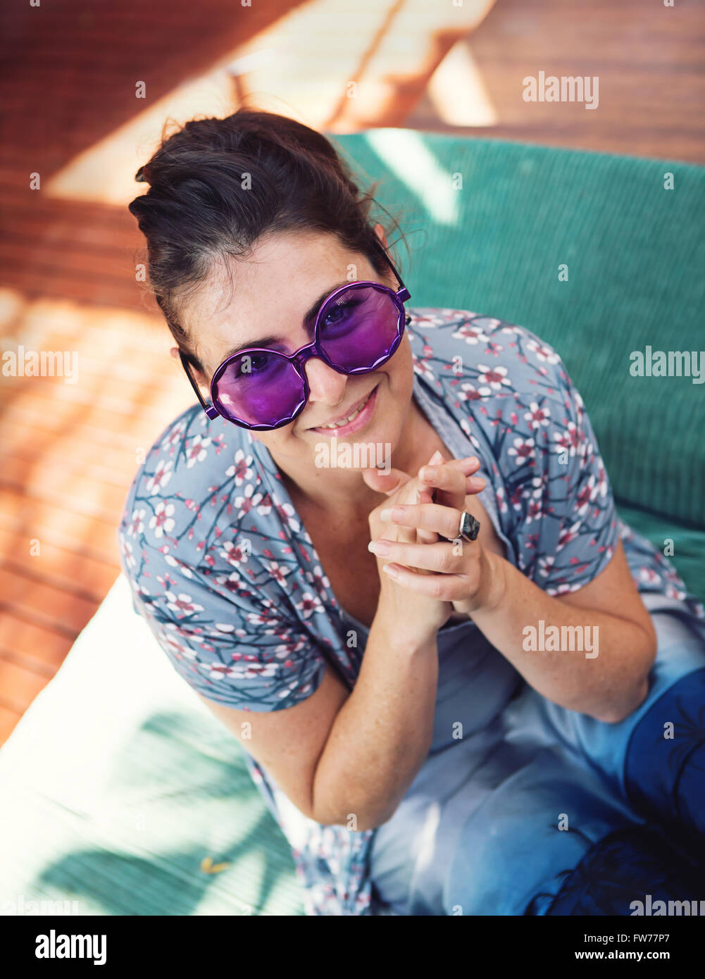 Donna in viola hippy occhiali da sole sorridente felicemente al suo partito Foto Stock