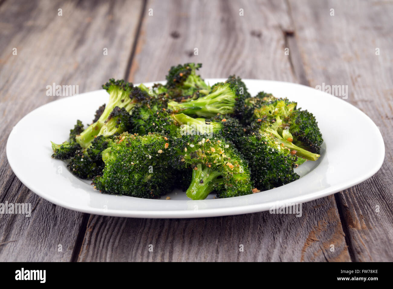 Cotto arrosto parmigiano aglio e olio di oliva broccoli lato piatto sul tavolo in legno Foto Stock