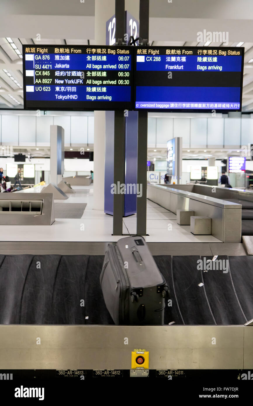 Bagagli sul convogliatore sotto sacchi orari di arrivo al terminal aeroportuale Foto Stock