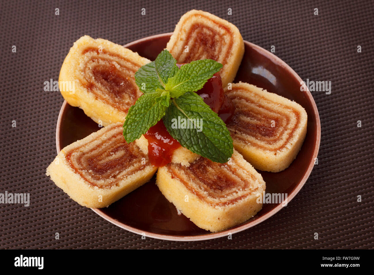 Bolo de rolo (swiss roll, roll cake) dessert brasiliano sulla piastra di marrone. Messa a fuoco selettiva Foto Stock