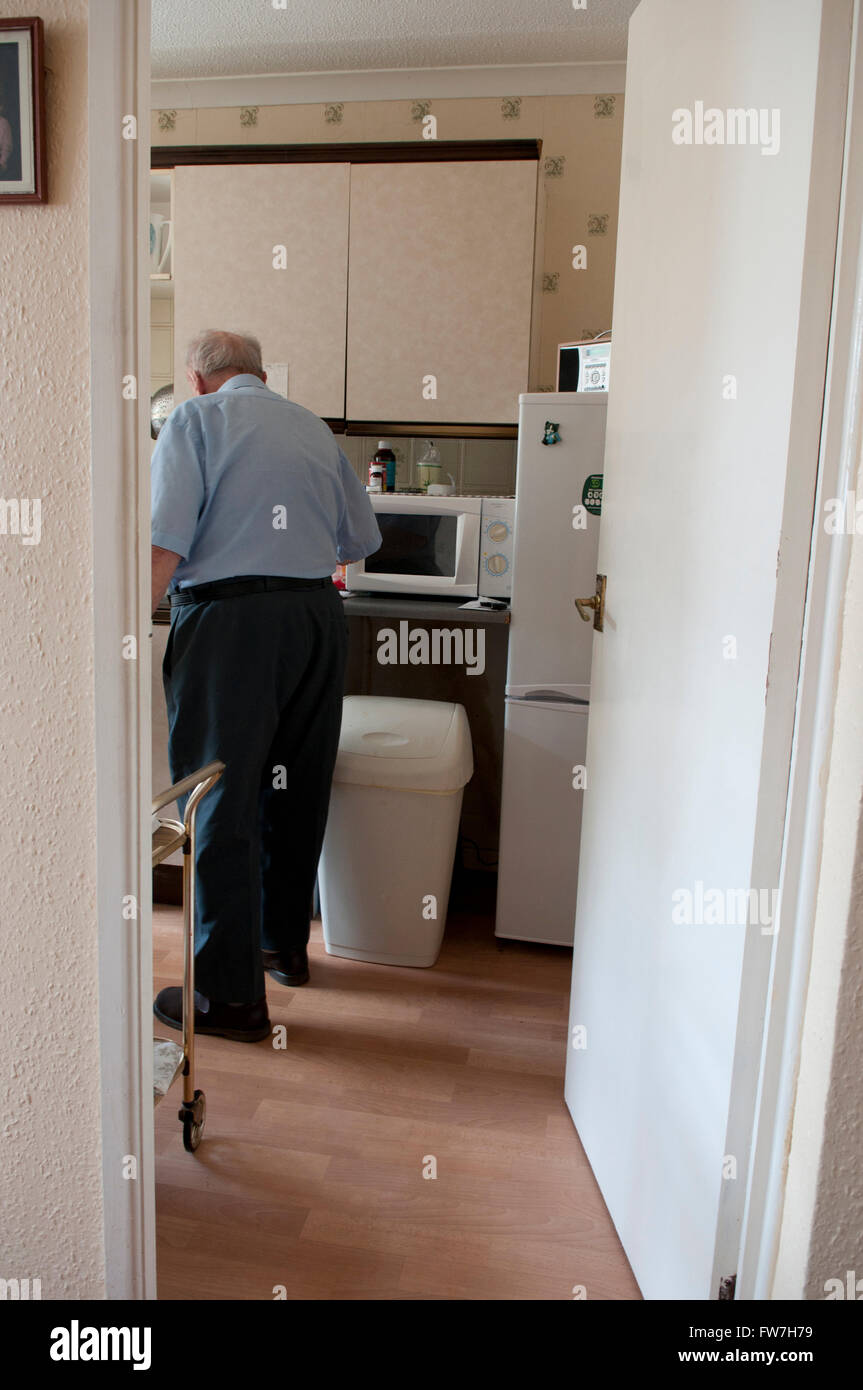 Vista posteriore di un uomo anziano nella sua cucina Foto Stock