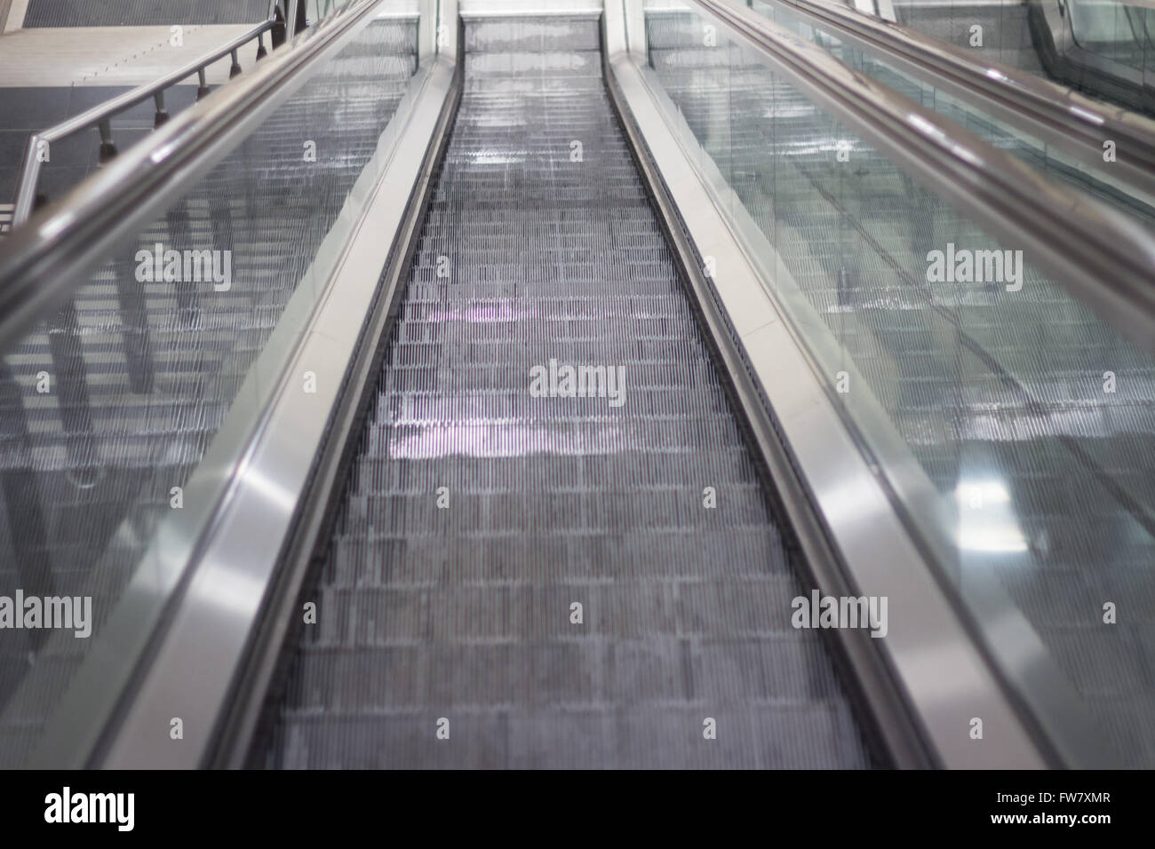 Guardando verso il basso sulla scala mobile nella stazione della metropolitana Foto Stock