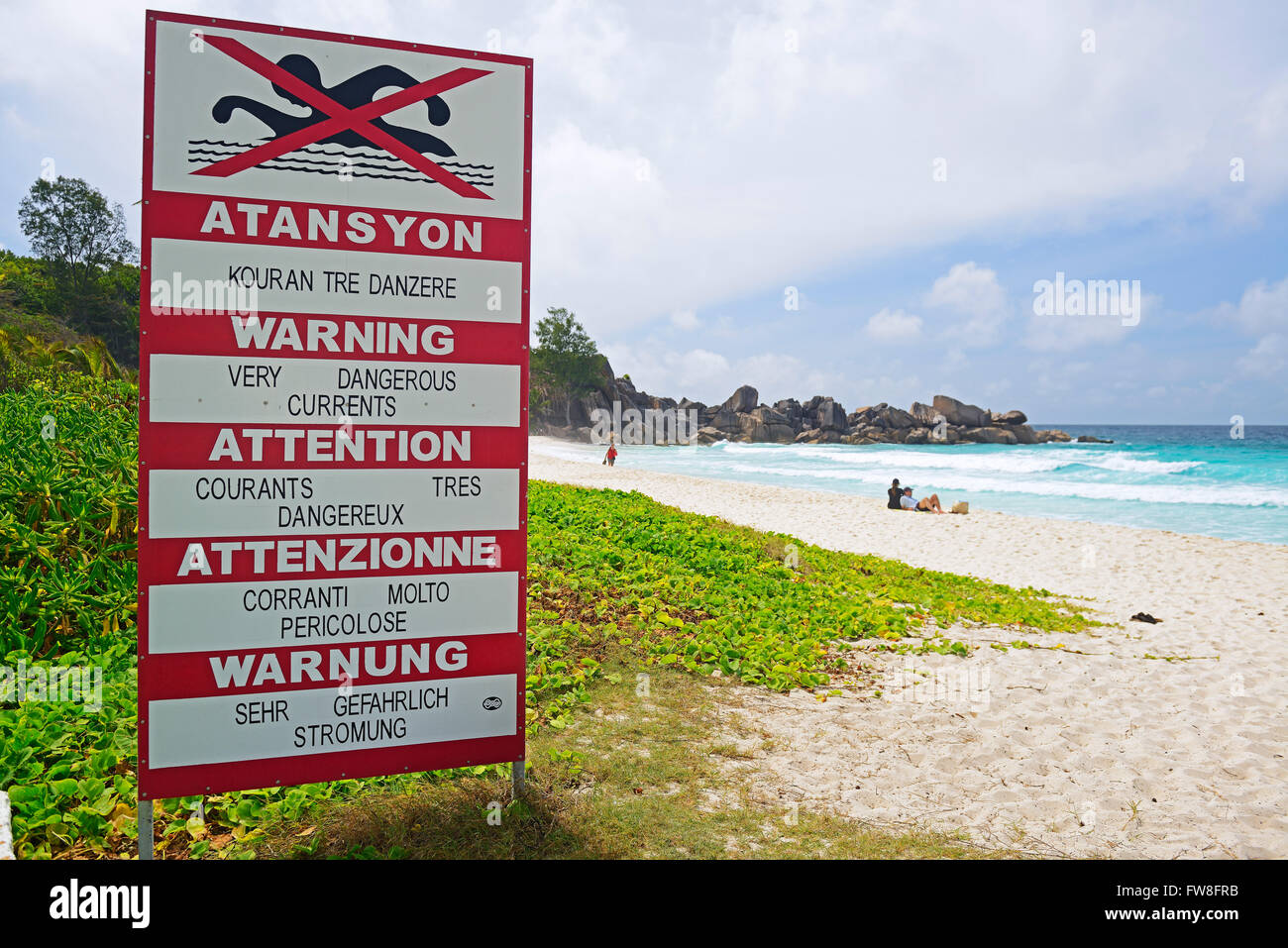 Schild mit Warnhinweisen in unterschiedlichen Sprachen auf Stroemungen, Traumstrand Grand Anse, Insel La Digue, Seychellen Foto Stock
