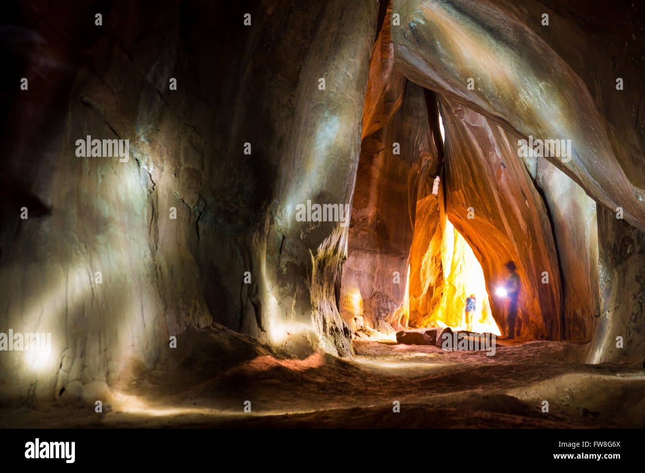 Avventurosa explorer torcia brilla all'interno della grotta Foto Stock