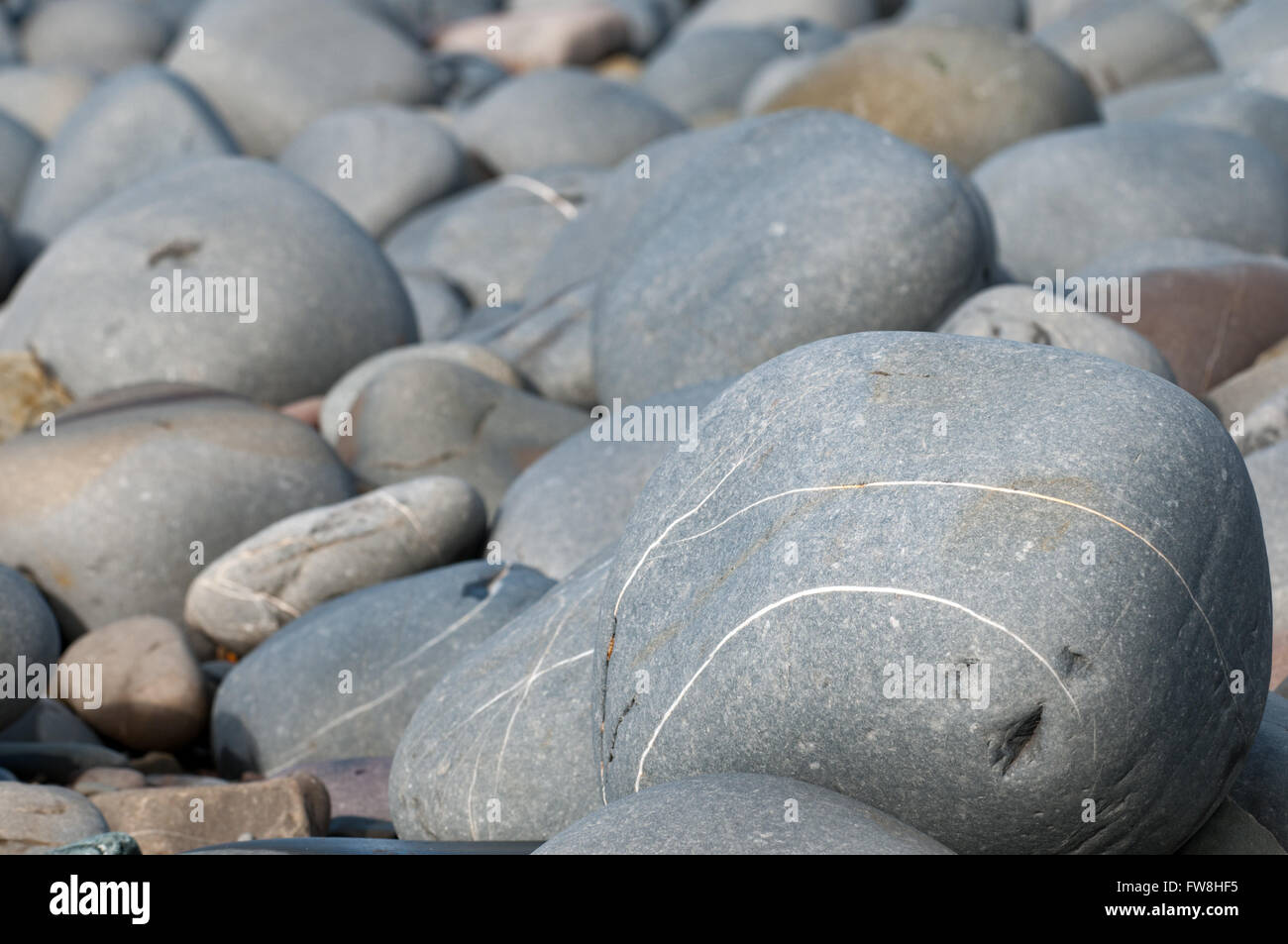 I ciottoli in spiaggia in primo piano di una scena costiere Foto Stock