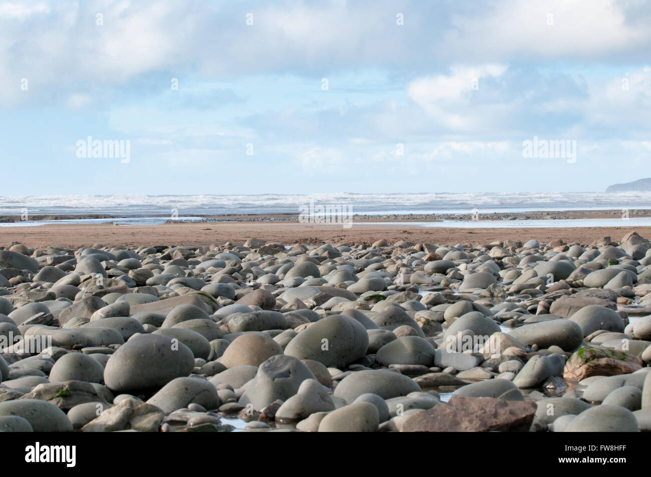 I ciottoli in spiaggia in primo piano di una scena costiere Foto Stock