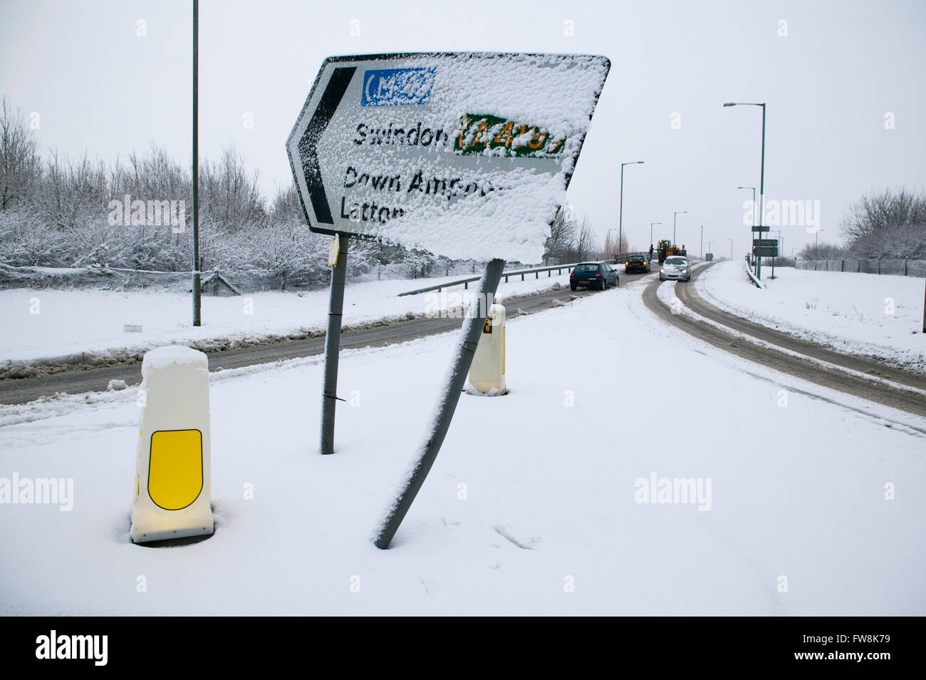 Segnaletica stradale e vuoto strade coperte di neve durante un pesante inverno tempesta di neve, non molti veicoli possono utilizzare le strade come essi sono coperte di ghiaccio e granite. Foto Stock