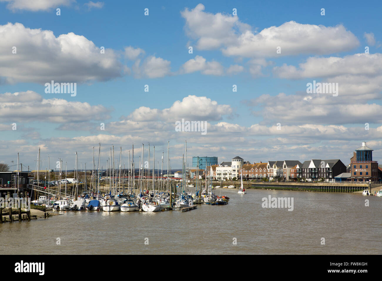 Vista guardando fino al fiume Arun a Littlehampton dove il fiume incontra il mare. Giornata di Primavera con il cielo blu e nuvole soffici Foto Stock