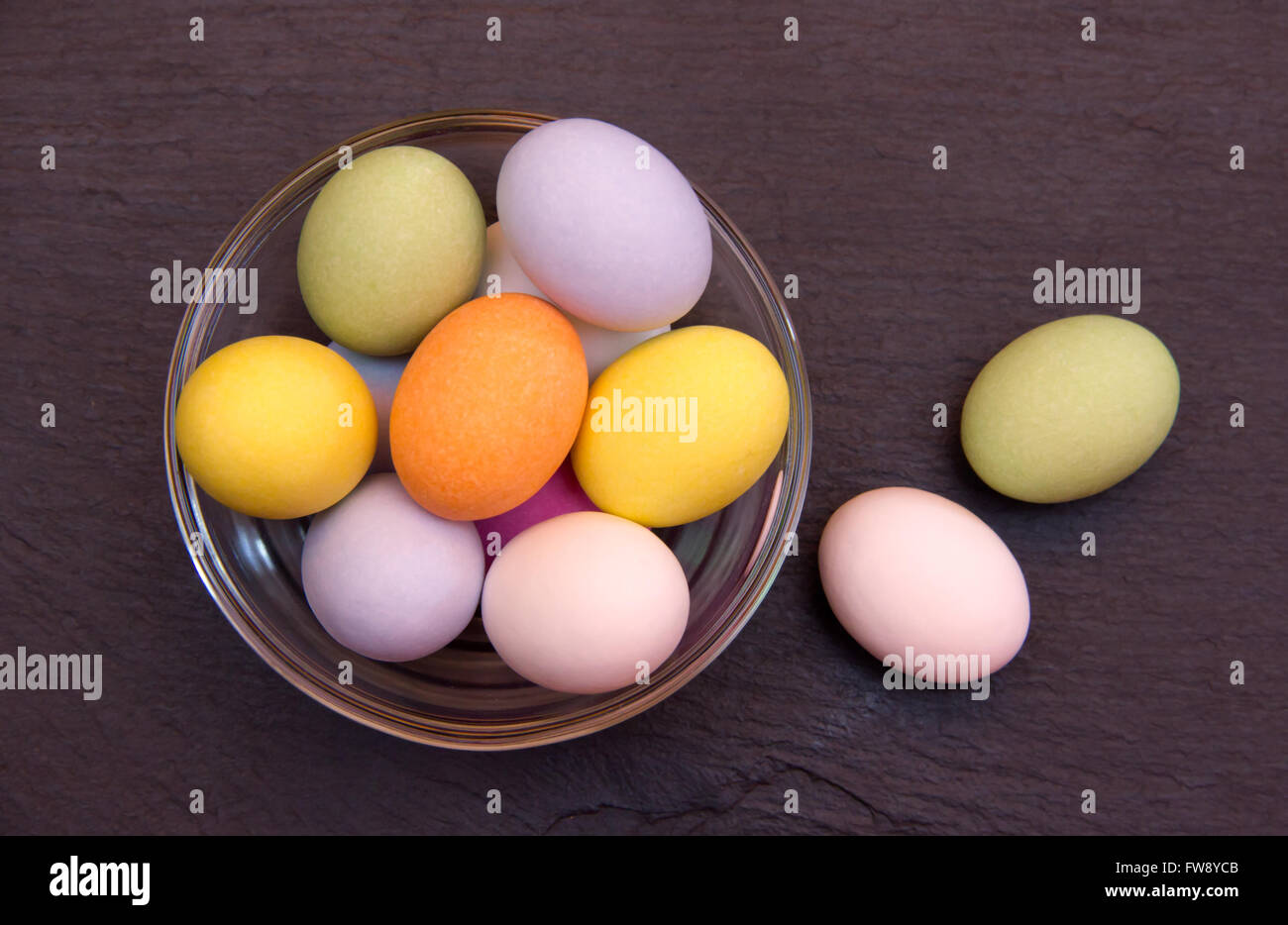 Uova colorate su una ciotola sulla sommità di ardesia viste dall'alto Foto Stock