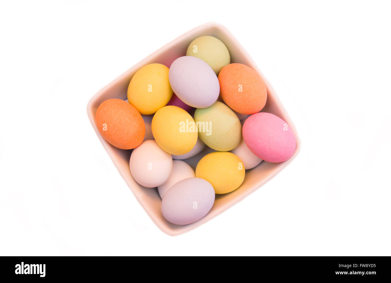 Uova colorate su un recipiente quadrato su sfondo bianco visto da sopra Foto Stock