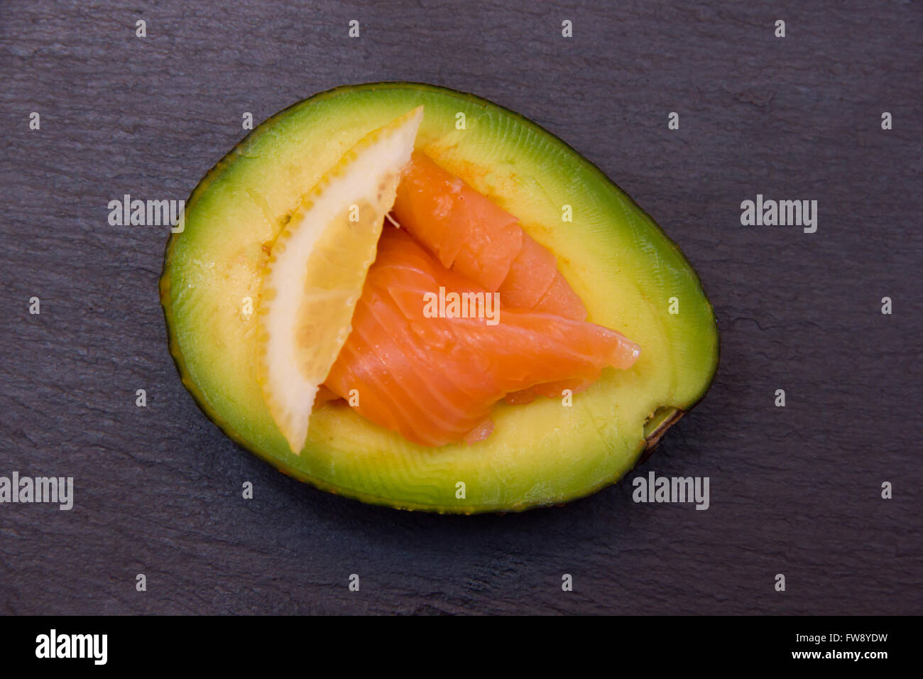 Mezz'avocado con salmone affumicato su top slate visto da sopra Foto Stock