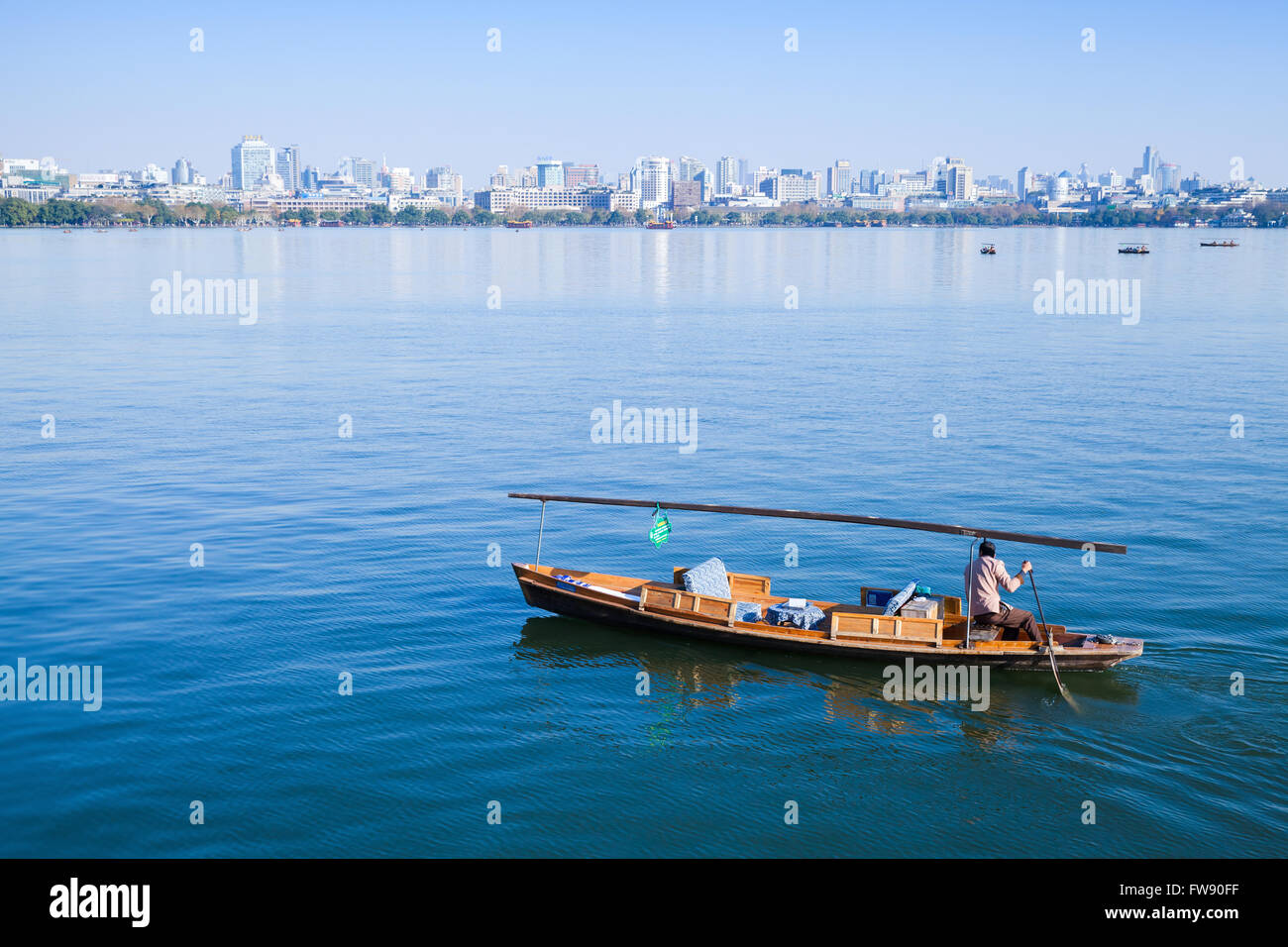 Hangzhou, Cina - 5 Dicembre 2014: Cinese tradizionale in legno barca di ricreazione con barcaiolo sul Lago Ovest. Famoso Parco Foto Stock