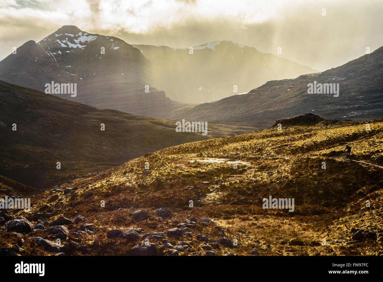 Mountain Biker iniziando la discesa da Bealach na i pidocchi in Torridon Highland scozzesi con Beinn Damh dietro Foto Stock