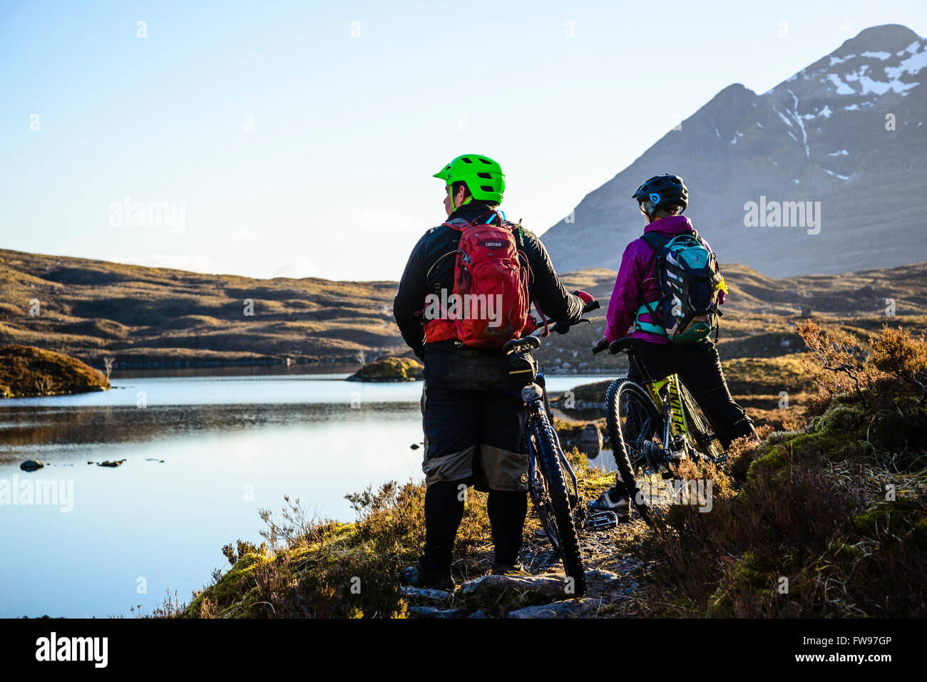 Gli amanti della mountain bike godetevi una pausa di riflessione da Loch un Eoin durante la discesa dal Bealach na pidocchi Torridon nelle Highland Scozzesi Foto Stock