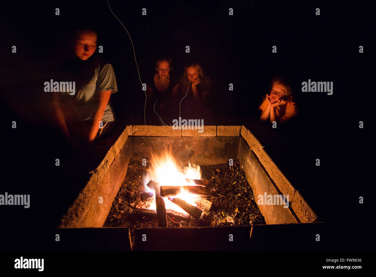 La famiglia intorno al fuoco pit in cabina di Table Rock State Park in Carolina del Sud. Foto Stock