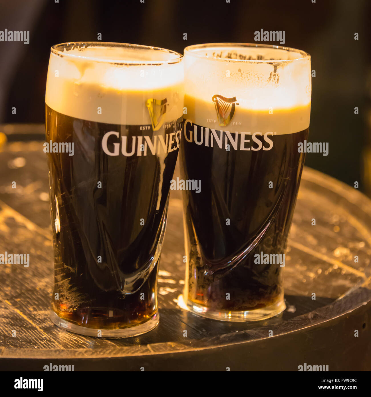 Bicchieri da birra con birra Guinness sul barile di legno nel pub irlandese di Dublino, Irlanda Foto Stock