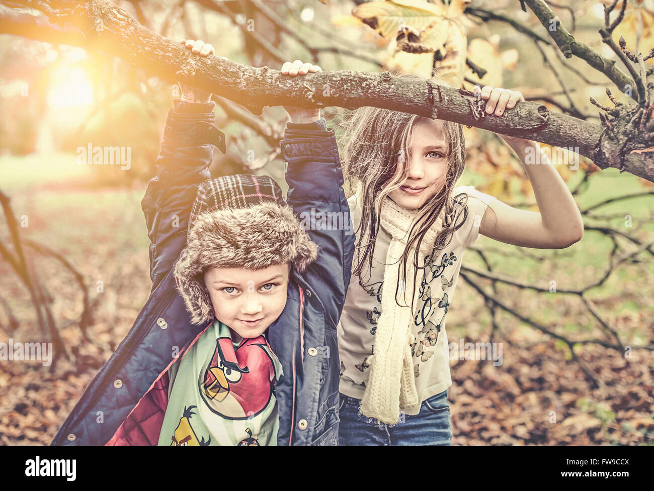 Due bambini che giocano nel parco di autunno nella giornata di sole Foto Stock