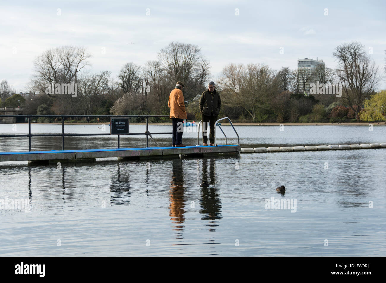 Due uomini in piedi sul pontile sulla serpentina, Hyde Park central London, England, Regno Unito Foto Stock