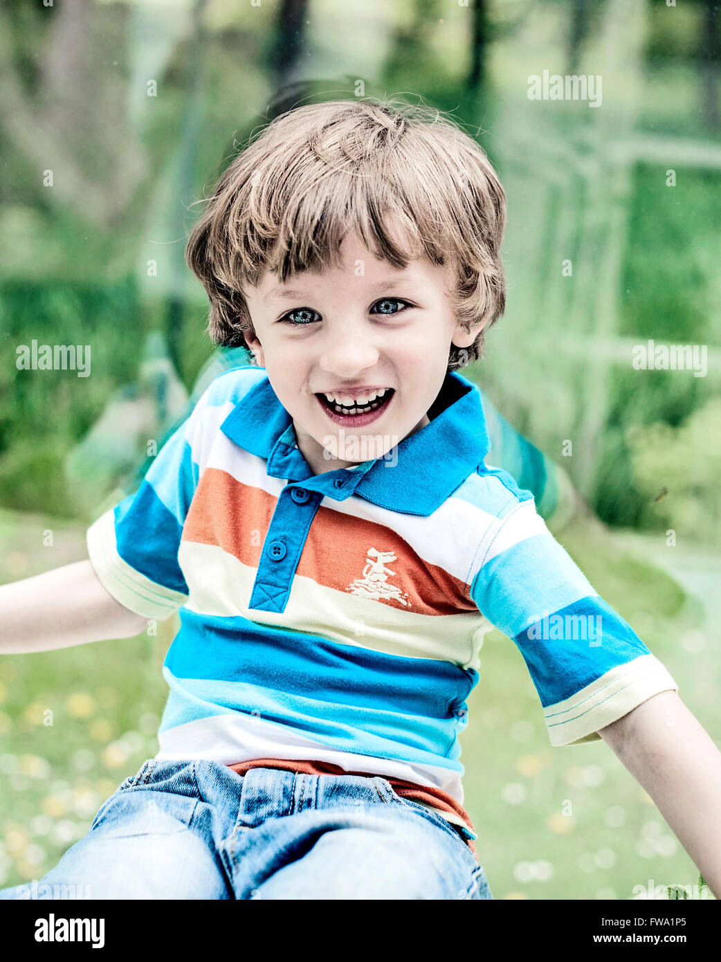 Un piccolo ragazzo felici giocando dalla finestra in casa Foto Stock