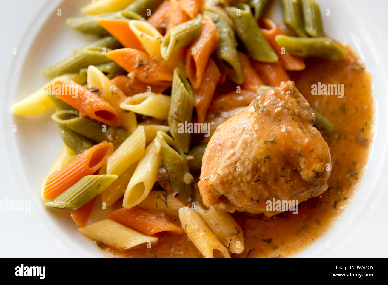 Pasta colorata con pollo sulla piastra Foto Stock