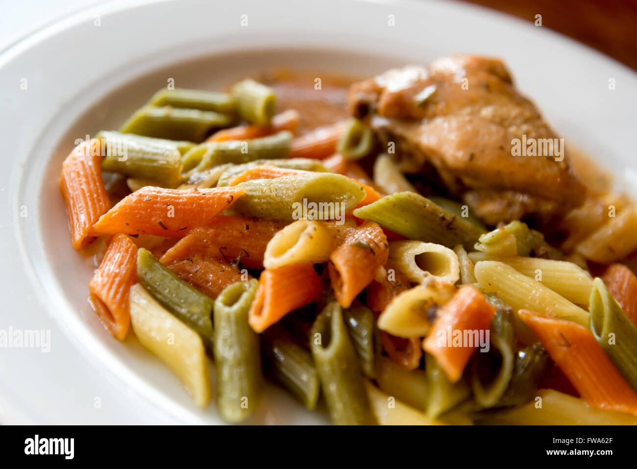 Pasta colorata con pollo sulla piastra Foto Stock