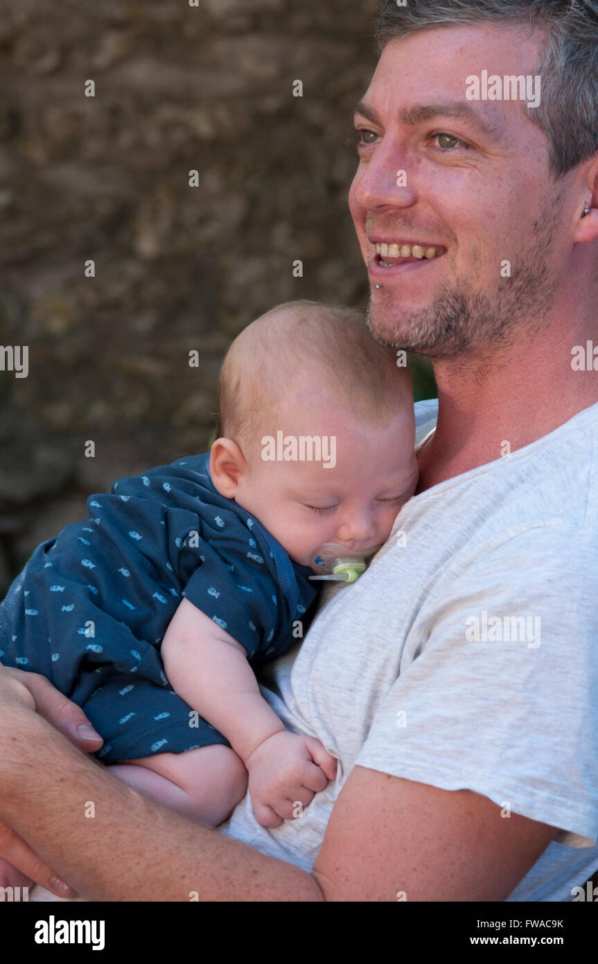 Padre sorridente, tenendo il suo bambino al di fuori Foto Stock