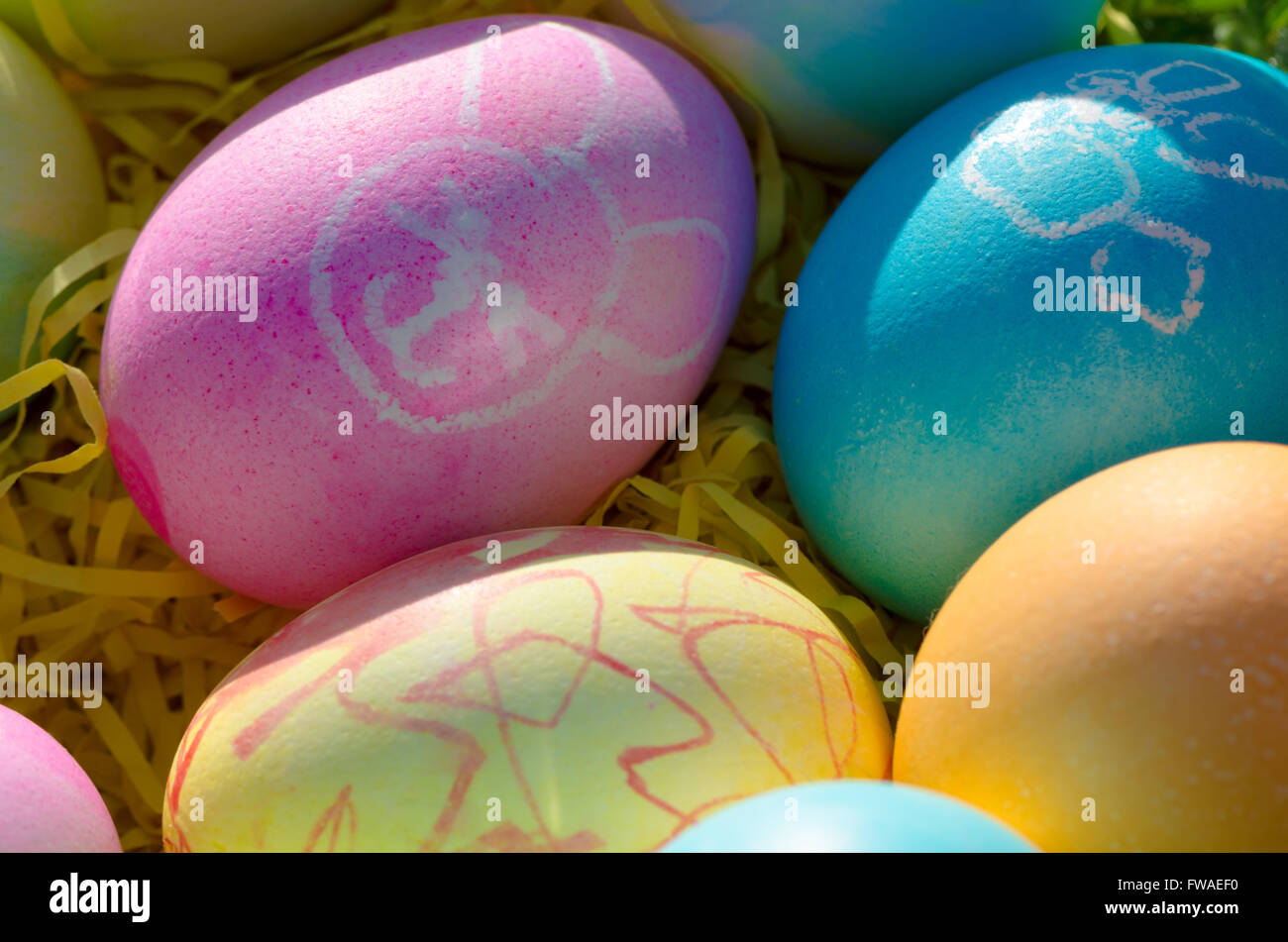Una ciotola di uova di pasqua con colorati arte e bunny dipinti. Foto Stock