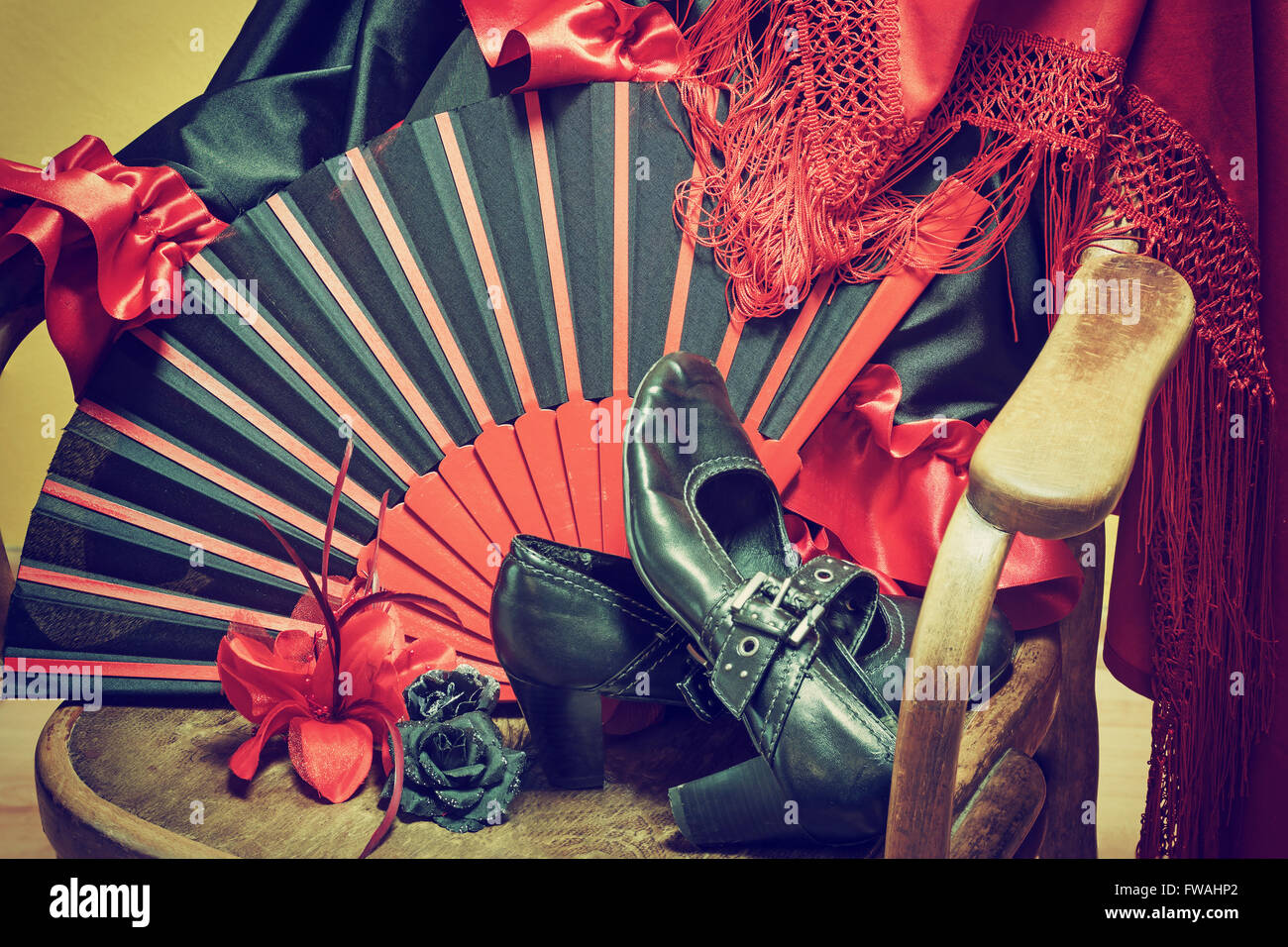 Abbigliamento per la danza flamenca. Nero scarpe, ventilatore, sciarpa  rossa con fiocchi di carta e le rose sono giacenti su un vintage sedia in  legno Foto stock - Alamy