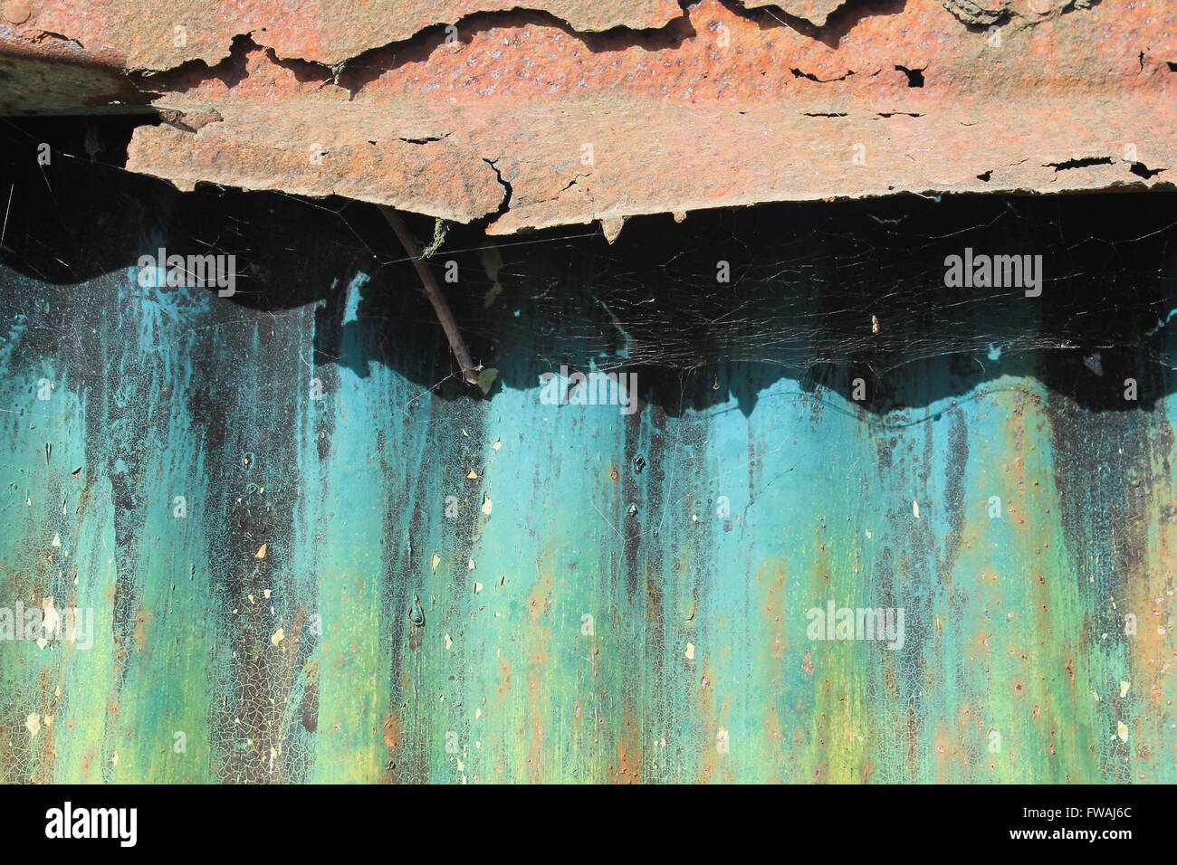Una vecchia capanna di stagno con dipinto luminosamente lamiera grecata e ruggine tetto Foto Stock