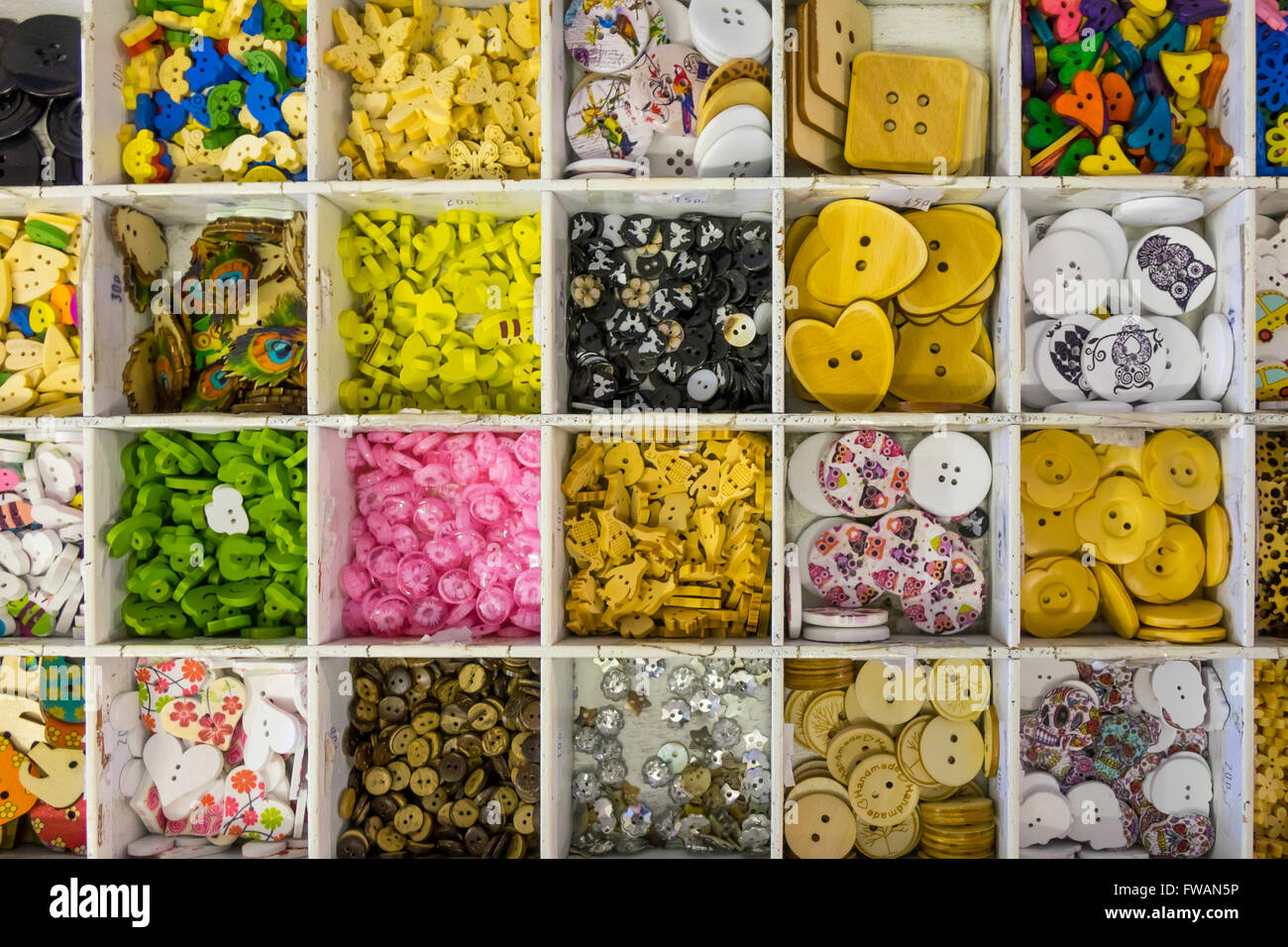 Display Haberdashers di novità fatti a mano i pulsanti colorati in una scatola di compartimenti Foto Stock