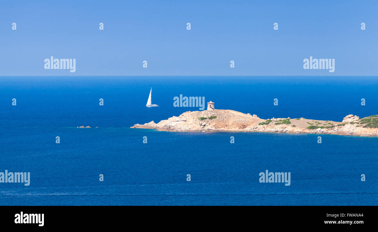 Sailing yacht va vicino alla costa rocciosa della Corsica. Panoramica estiva seascape Foto Stock