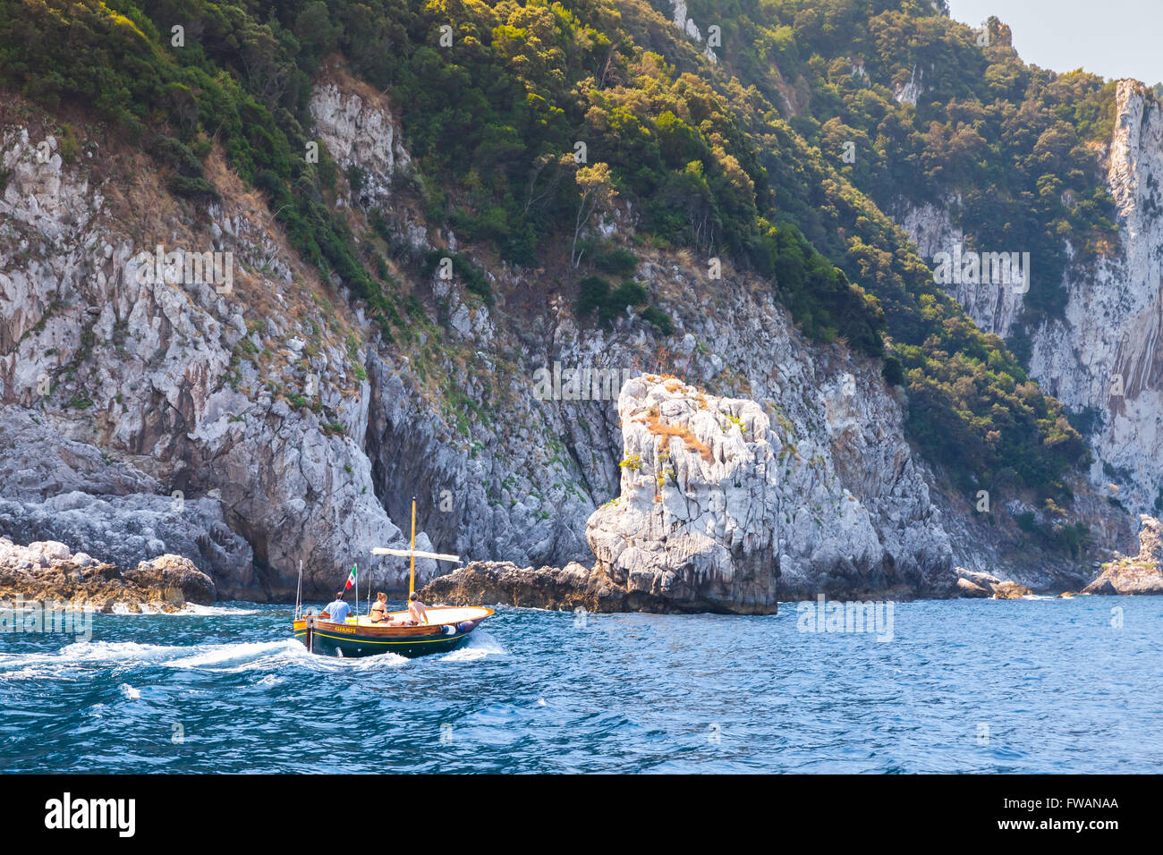 Capri, Italia - 14 agosto 2015: piccolo piacere motoscafo con i normali turisti andare vicino a rocce costiere di isola di Capri, Italia Foto Stock