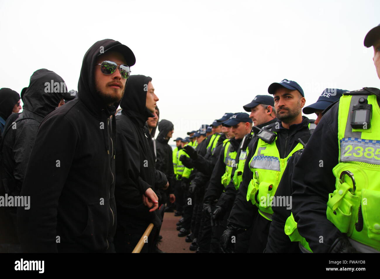 Dover, Kent, Regno Unito. Il 2 aprile 2016. Anti manifestanti fascista volto la linea di polizia sul lungomare di Dover. Gruppi Anti-Fascist, comprese Londra Anti-Fascists, Kent Anti-Racism Network (KARN) e unire le forze contro il fascismo (UAF), prendere per le strade di dover contrastare dimostrano una estrema destra unità marzo attraverso il centro della città ha portato dall'ala destra gruppo Sud Est Alliance, che include il Fronte Nazionale (NF) e della difesa inglese League (EDL). Penelope Barritt/Alamy Live News Foto Stock