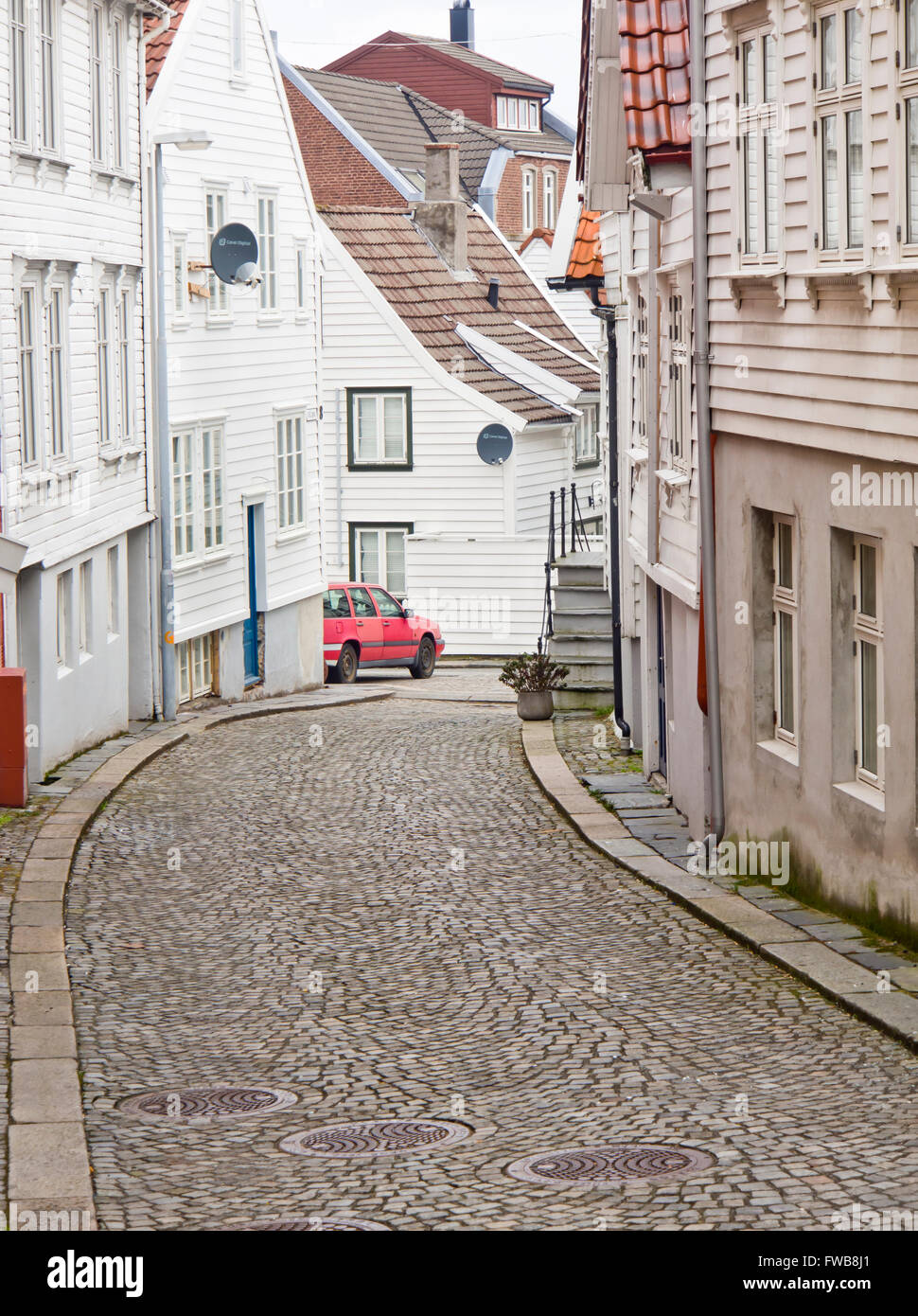 Strada stretta con ciottoli e infissi bianchi case nel centro di Stavanger, Norvegia Nytorget area Foto Stock