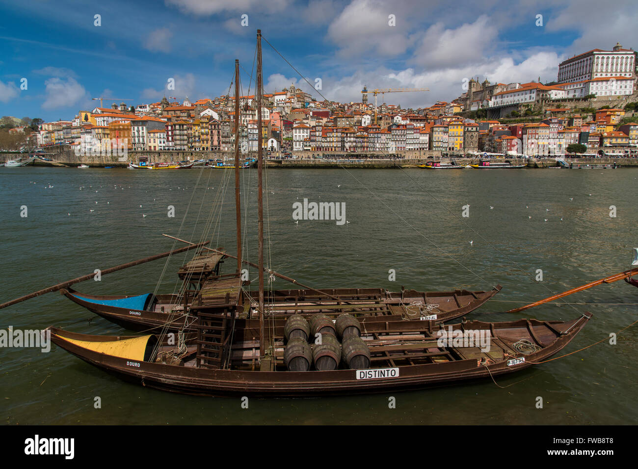 Tradizionale barca Rabelo progettati per trasportare il vino verso il basso lungo il fiume Douro con lo skyline della citta' dietro, Porto, Portogallo Foto Stock