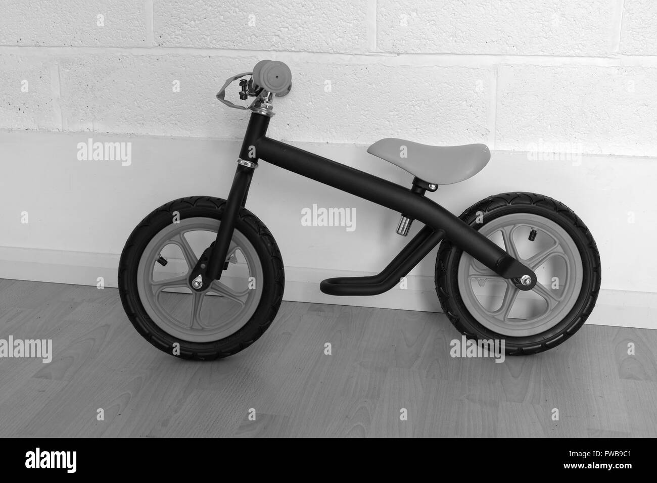 Un giovane bambino è il primo bilancio in bici in nero con ruote rosse.Marzo 2016 Foto Stock