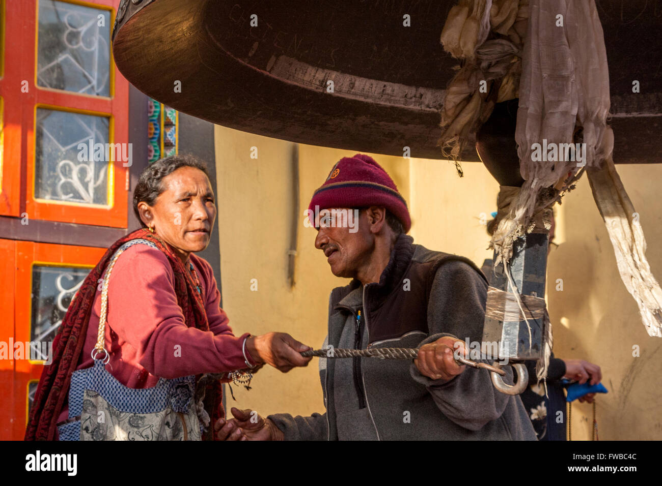 Bodhnath, Nepal. Suoneria campana gigante per celebrare il periodo del nuovo anno tibetano. Foto Stock