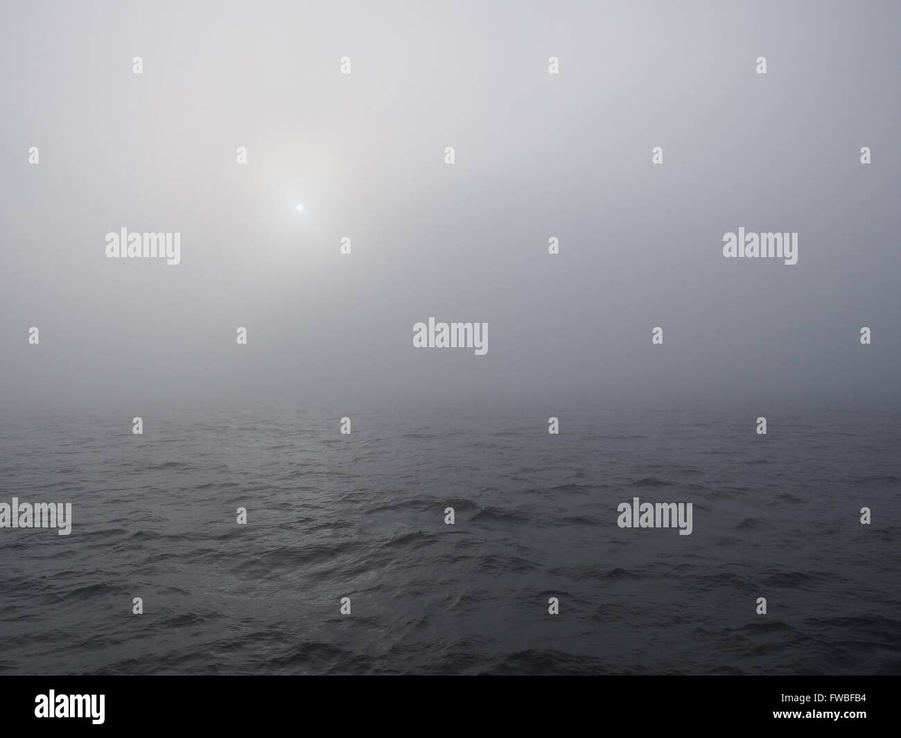 Densa nebbia oltre il mare con Sun Foto Stock
