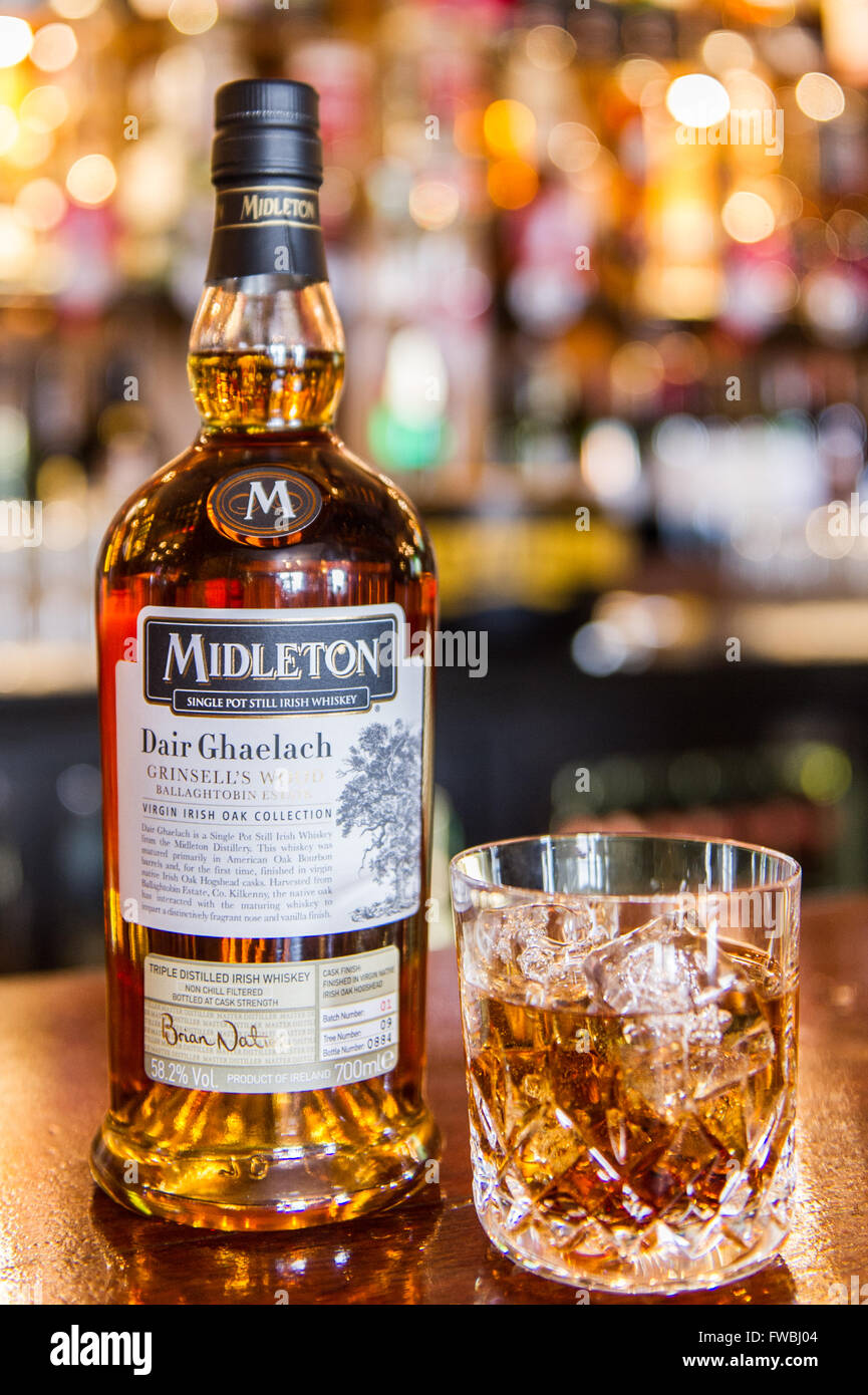 Bottiglia di raro Midleton Dair Ghaelach single pot ancora Irish Whiskey e un bicchiere di whiskey con cubetti di ghiaccio in un bar in Irlanda. Foto Stock