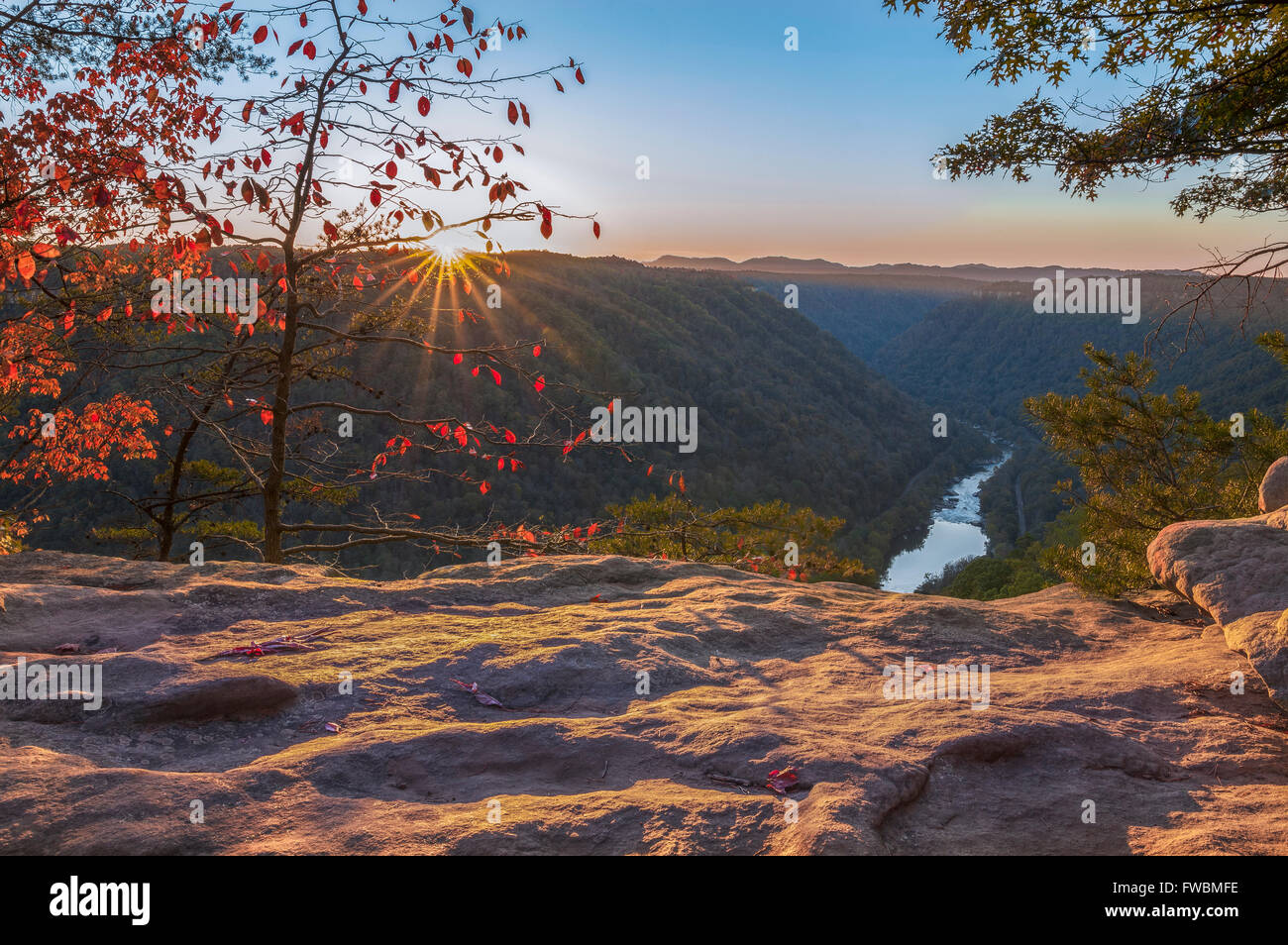 Il sole scende al di sotto della pittura di monti la sua luce dorata sulla trama di molti strati di New River Gorge in West Virginia. Foto Stock