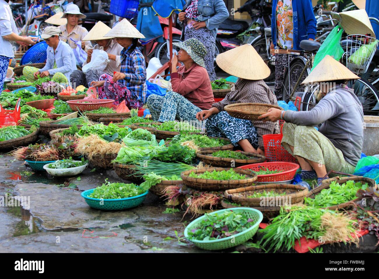 Onorevoli vietnamita la vendita di verdure fresche sul marciapiede al mercato, Hoi An, Vietnam Asia Foto Stock