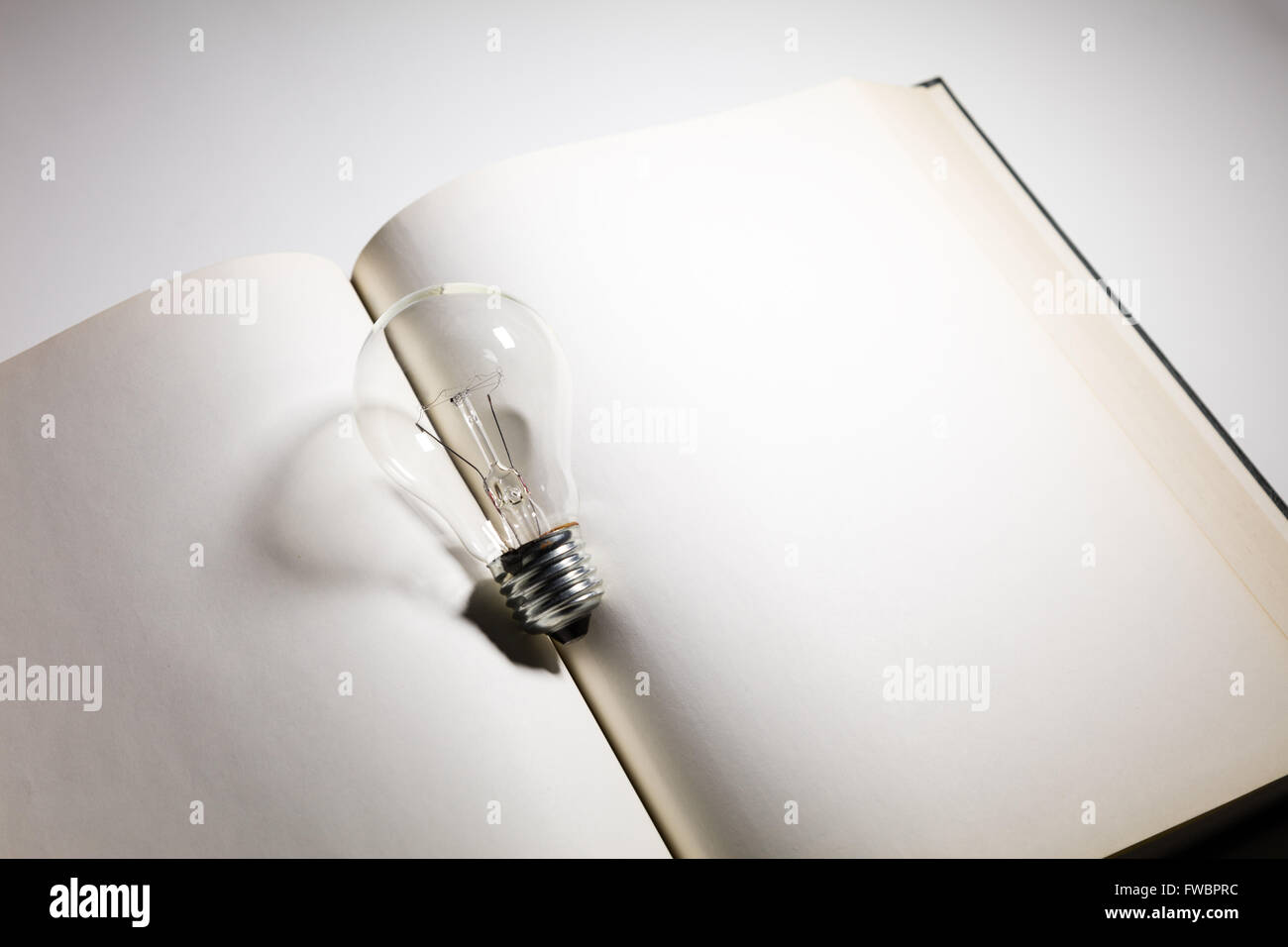Prenota e la luce della lampadina, business education concetto. Foto Stock