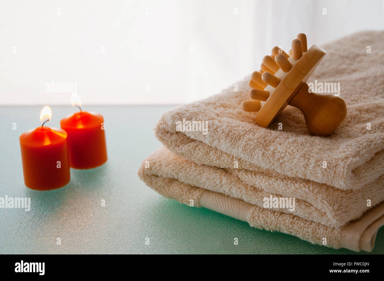 Spa: strumento di massaggio, asciugamano e candele accese. Foto Stock
